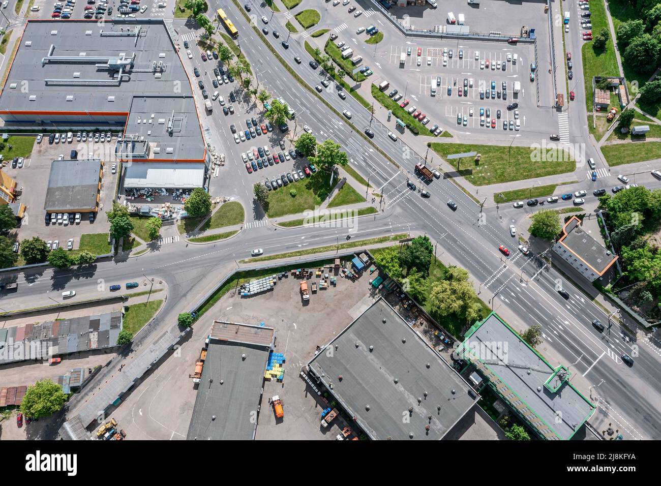 overhead view of urban crossroad near shopping mall and parking lot with cars Stock Photo