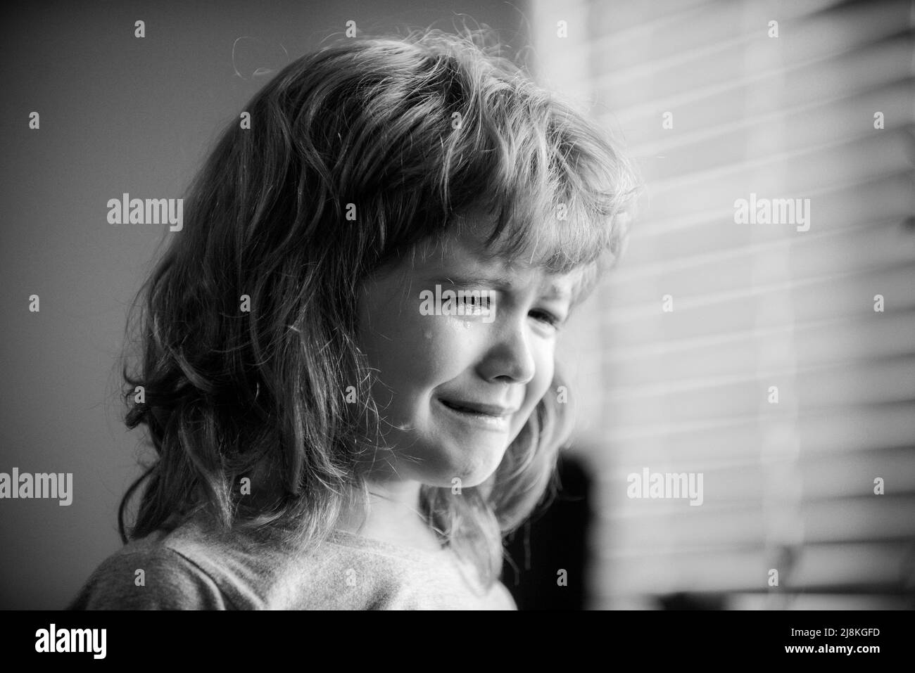 Blonde cries with tears. Upset child. Violence in family over children. Concept of bullying, depressive stress or frustration. Kid close up view. Pure Stock Photo