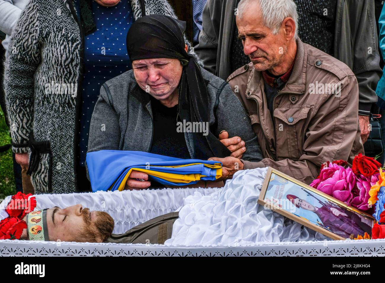 Balabyne, Ukraine. 13th May, 2022. (EDITORS NOTE: Image depicts death).Parents of Sergey Titov, sergeant of the National Guard of Ukraine, killed by Russian shelling in Orikhiv, sit by his coffin at the cemetery of Balabyne, Zaporizhia region. Russia invaded Ukraine on 24 February 2022, triggering the largest military attack in Europe since World War II. (Credit Image: © Rick Mave/SOPA Images via ZUMA Press Wire) Stock Photo