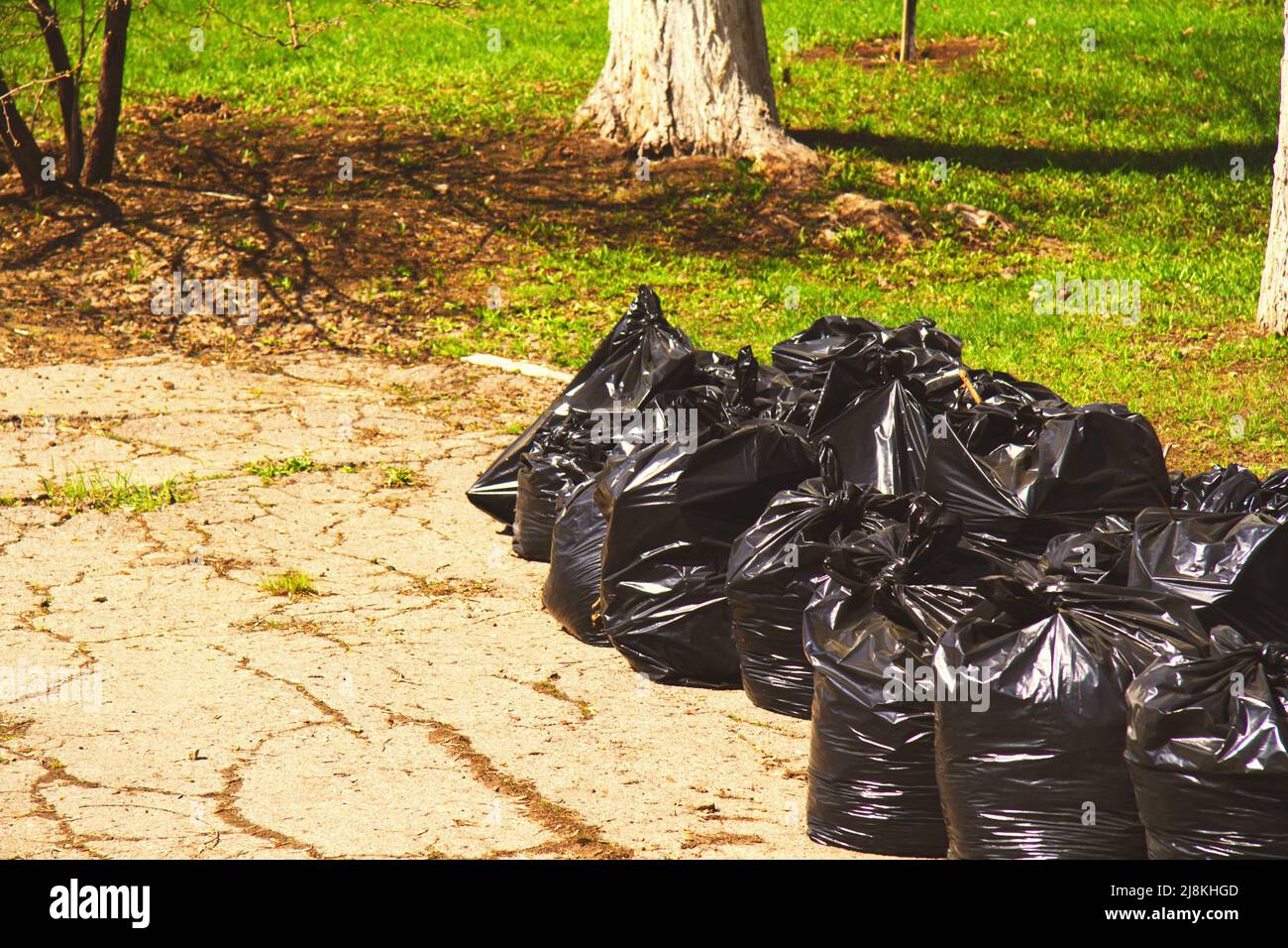 City street cleaning. Garbage in black bags on the streets of the city. Stock Photo