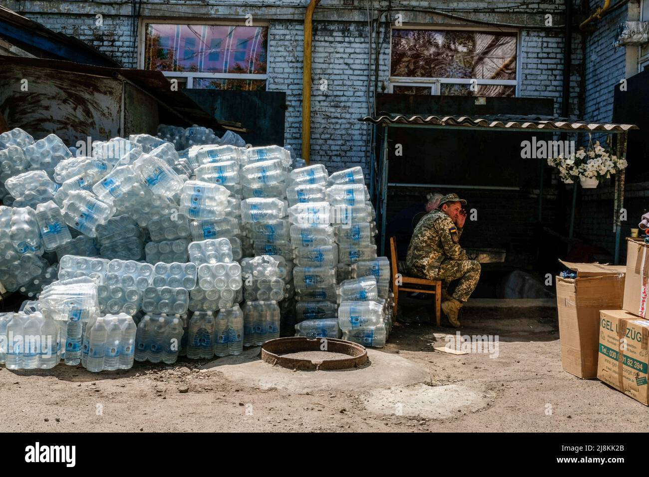 A soldier sits next to a pile of water bottles at Zaporizhia military Hospital. Zaporizhia is an industrial city of Ukraine of about 700.000 inhabitants, it has the biggest hospital of the region where every day many soldiers are brought from war frontline to be treated. Every day refugees from all over eastern Ukraine arrive to Zaporizhia Center for displaced people fleeing from combat zones or occupied territories by the Russian army. Russia invaded Ukraine on 24 February 2022, triggering the largest military attack in Europe since World War II. (Photo by Rick Mave/SOPA Images/Sipa USA) Stock Photo