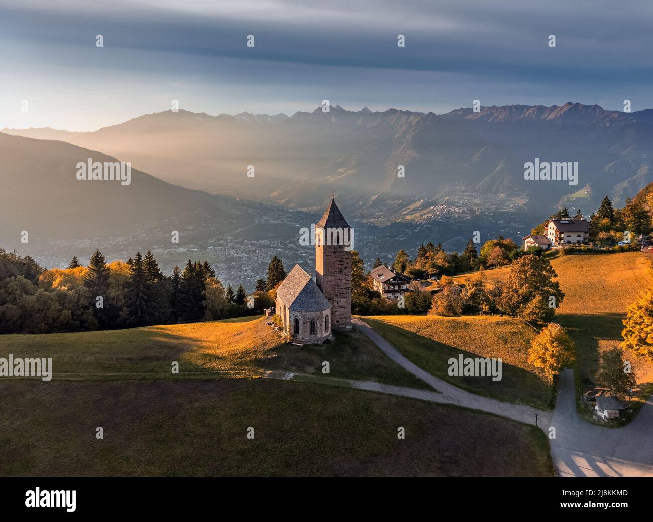 Hafling, Italy - Aerial view of the mountain church of St. Catherine (Chiesa di Santa Caterina) near Hafling - Avelengo on a warm autumn sunset with t Stock Photo