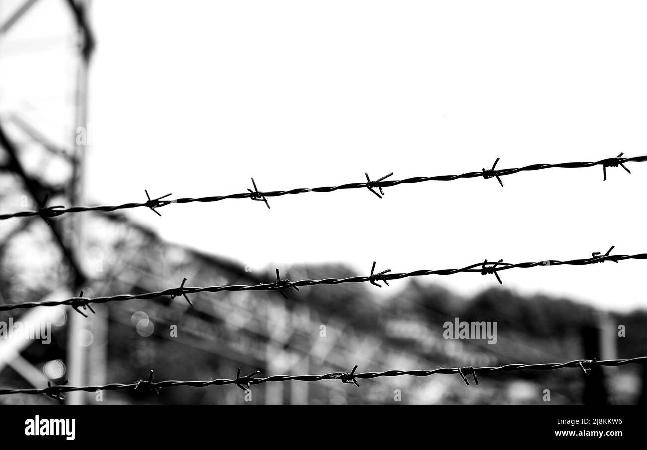 three barbed wires in a prison camp for the segregation of prisoners and to prevent prisoners from escaping Stock Photo