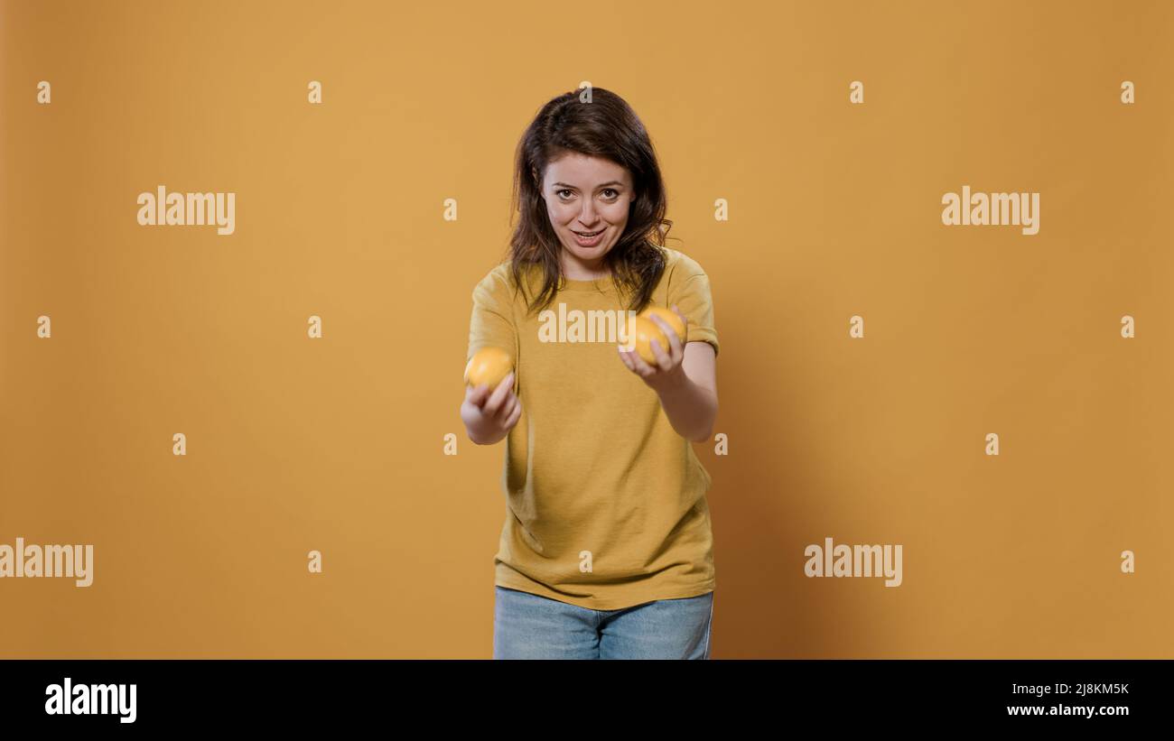 Playful woman acting silly trying to juggle oranges being funny while  dropping them in studio. Individuality concept of person with fun and goofy  personality showing juggle talent Stock Photo - Alamy