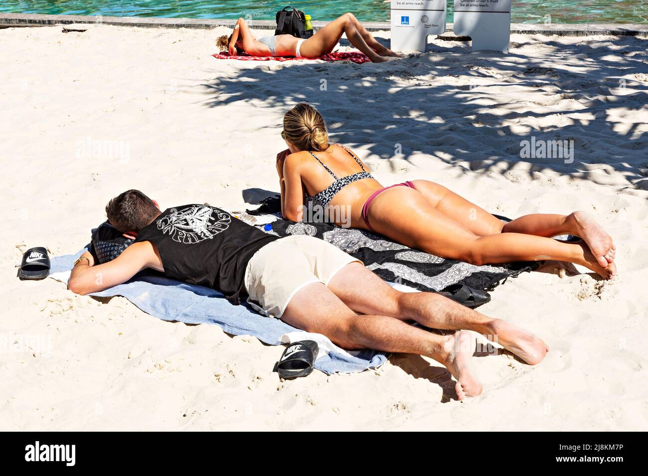 Brisbane Australia / A young couple enjoy the sunshine at Streets Beach an urban man made swimming beach. Stock Photo