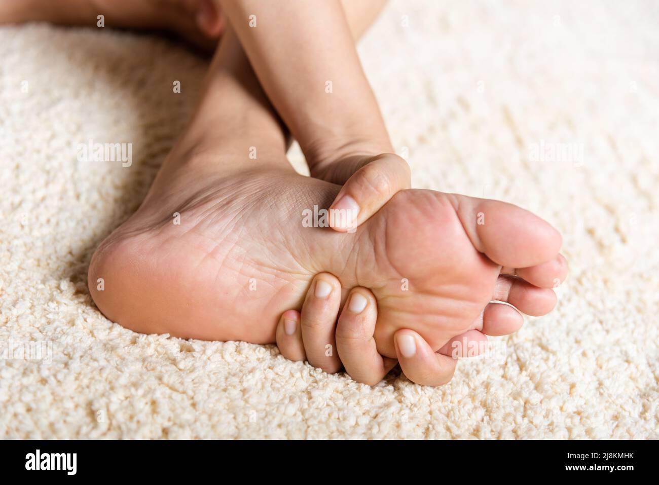 Foot pain, Asian woman feeling pain in her foot at home, female suffering  from feet ache use hand massage relax muscle from soles in home interior,  He Stock Photo - Alamy