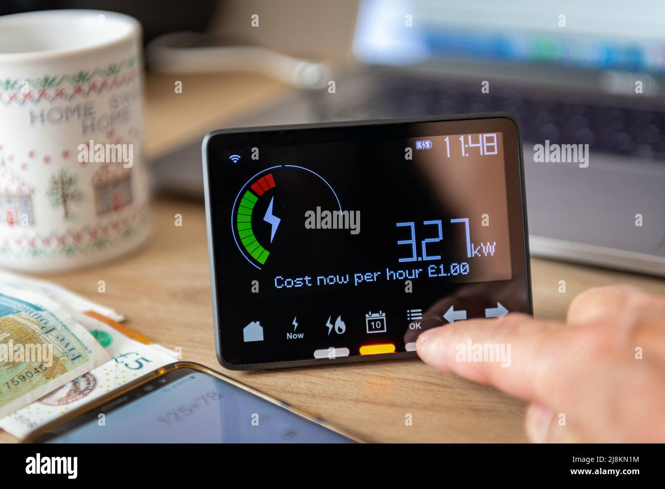 A person checking and calculating rising home energy cost with smart meter. Inflation, cost of living concept. Stock Photo