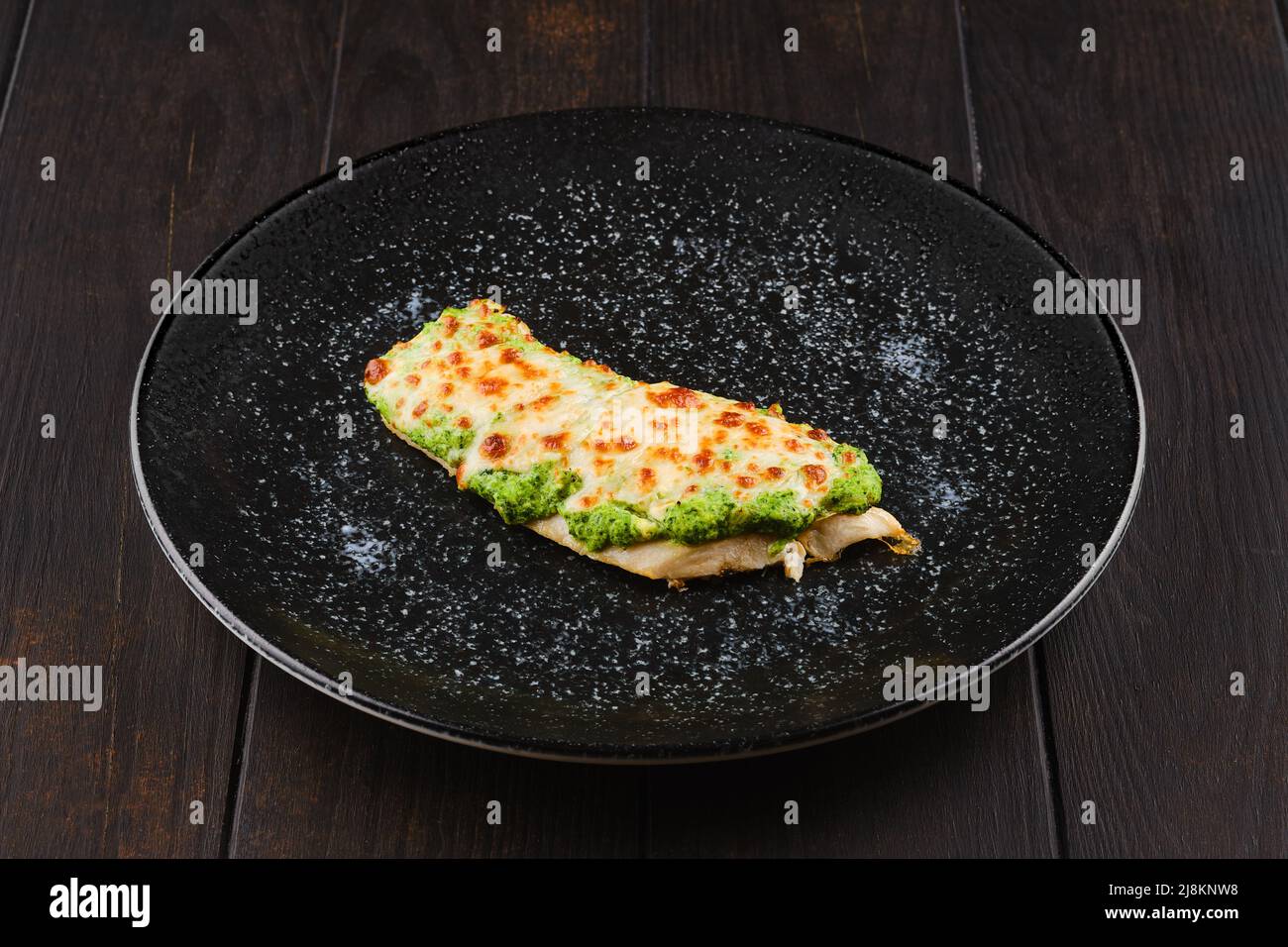 Fried fish fillet with green salsa sauce on a plate Stock Photo