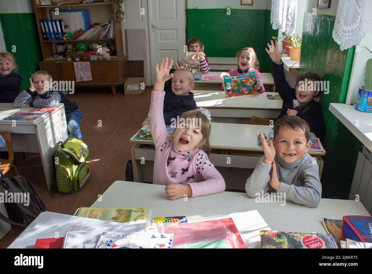 3.11. 2014 Ukraine Mervichi, happy first-graders raise their hands in the classroom to answer Stock Photo