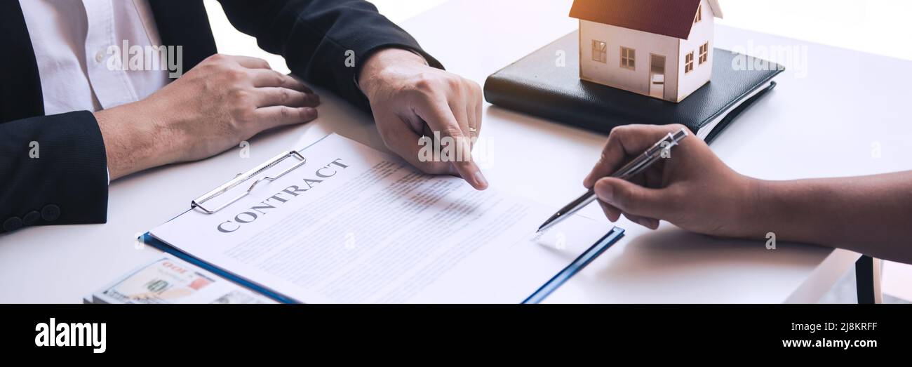 Real estate agent congratulations to new buyer by giving house model to