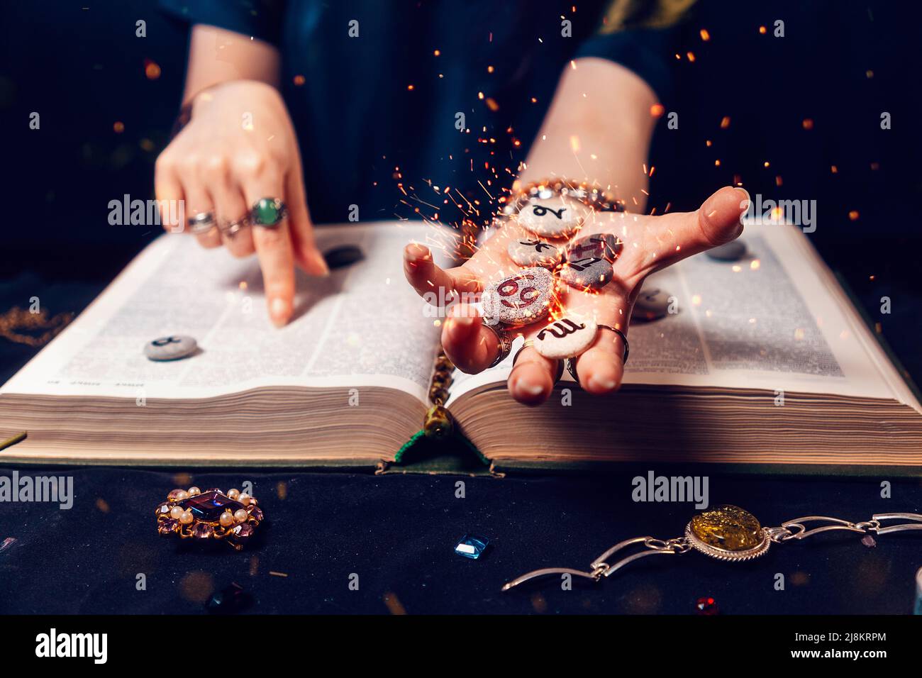 Fortune teller's hand holds the sparkling zodiac stones in the palm of