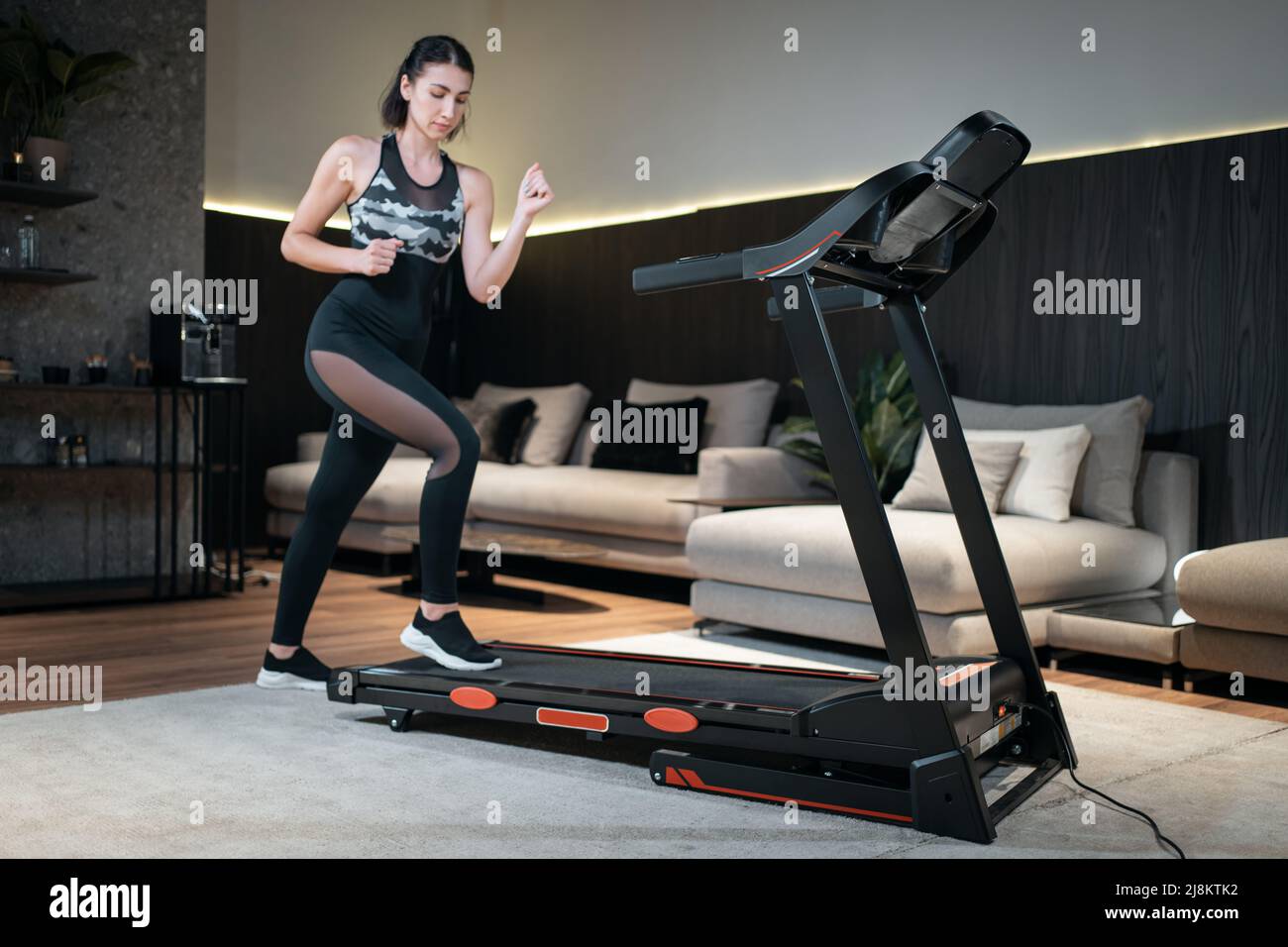 female feet running on treadmill in sport shoes, close up Stock Photo