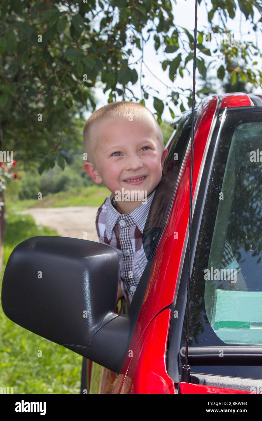 looked out from the window of the red car little boy Stock Photo - Alamy