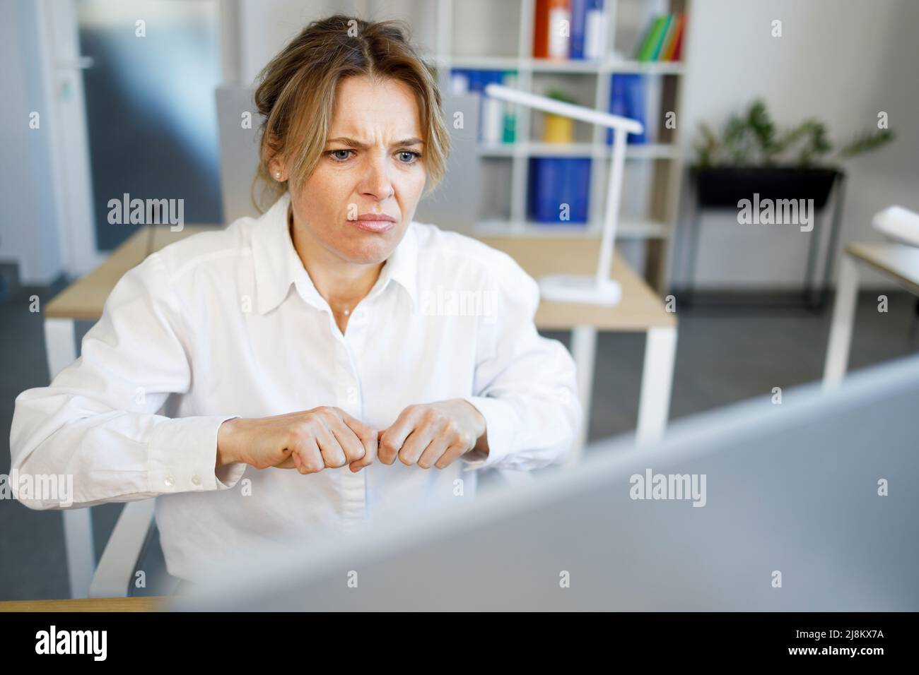 Angry business woman looking excitedly at computer screen Stock Photo ...