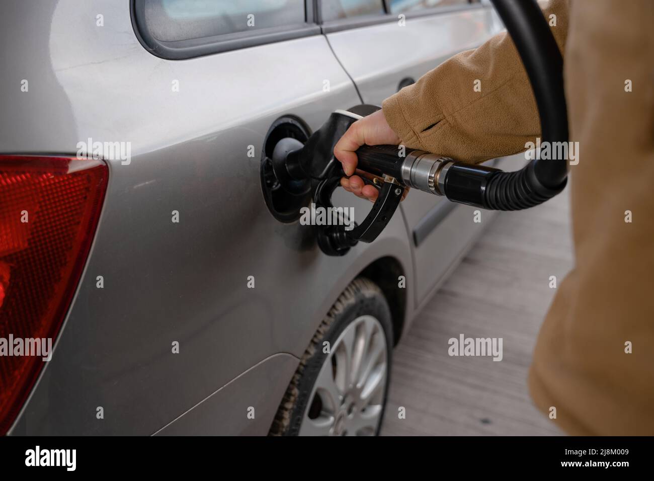 A man filling fuel tank of his car with diesel fuel at the gas station