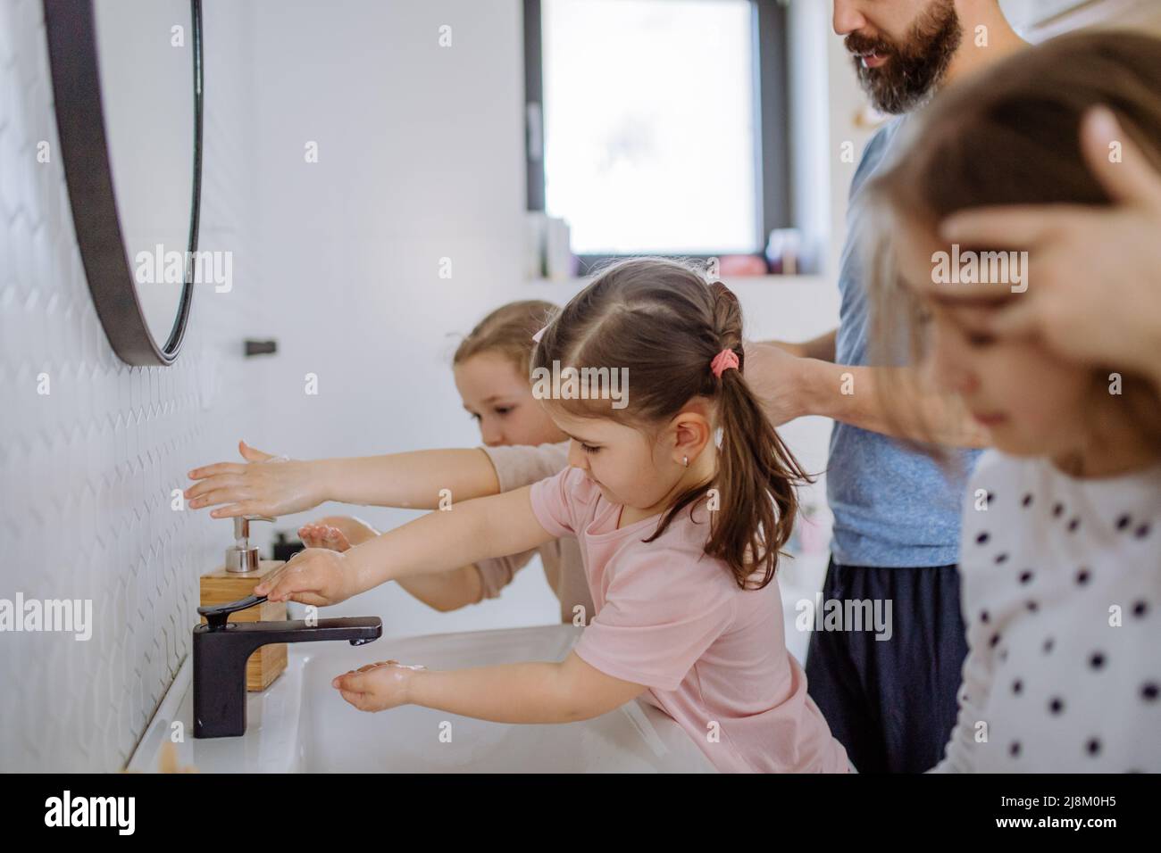 Father with three little children in bathroom, morning routine concept. Stock Photo
