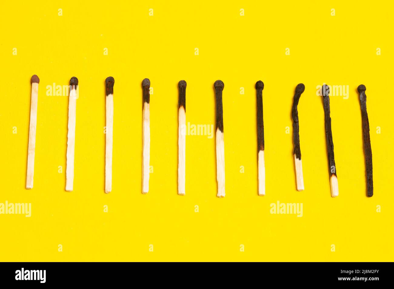 Different stages of match burning. Burnt matches on yellow background