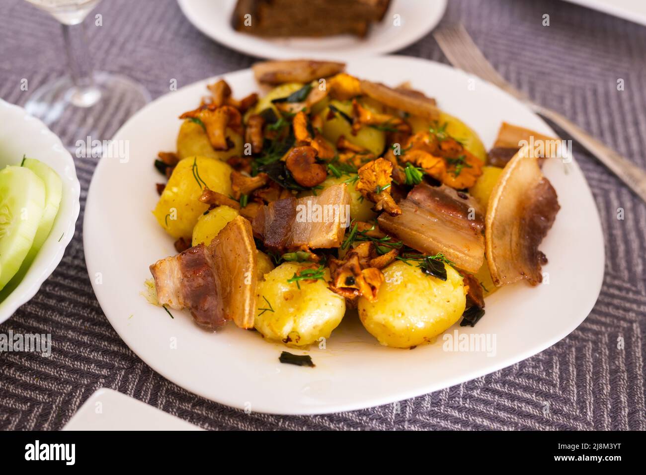 baked potatoes with chanterelles and bacon served with herbs on white