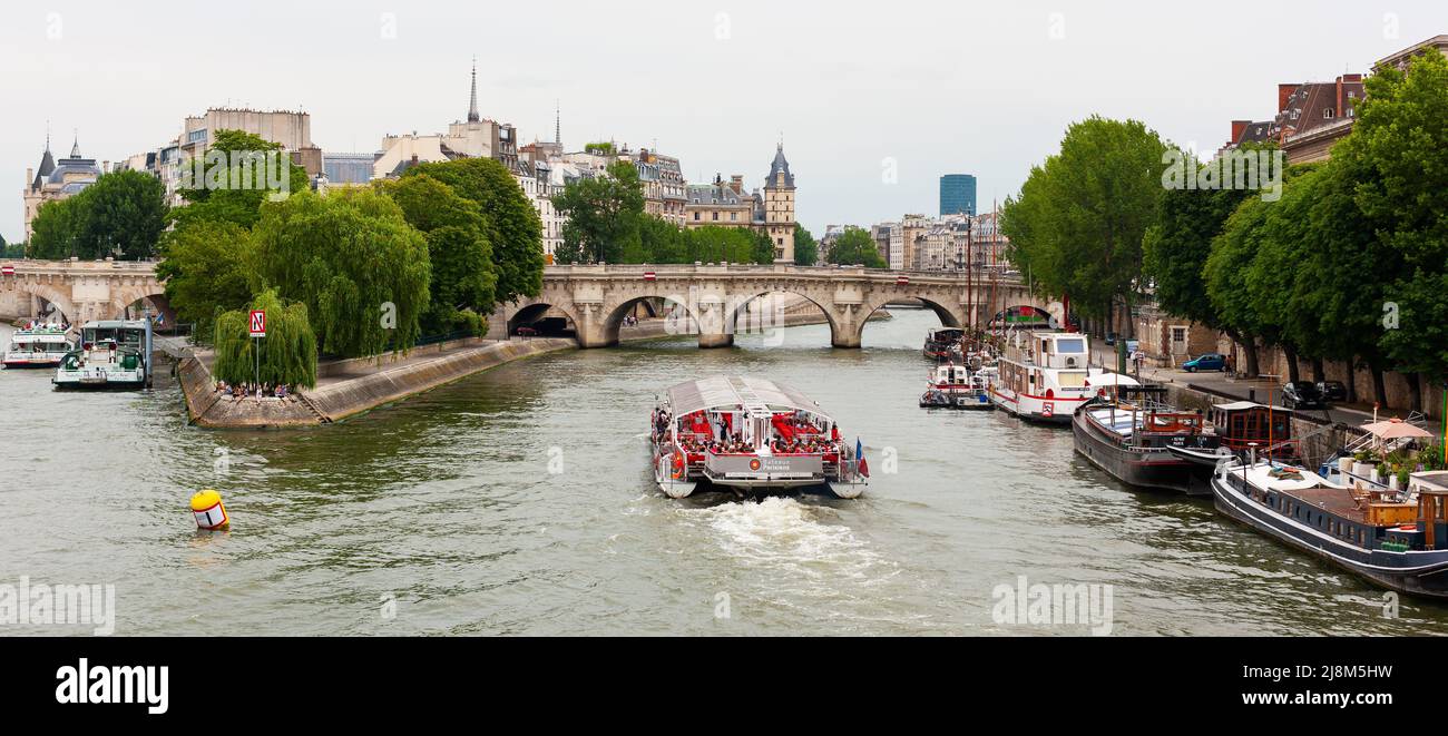 Paris, France - July 21, 2010 : Tour boat on Seine River sailing towards Pont Neuf. Stock Photo