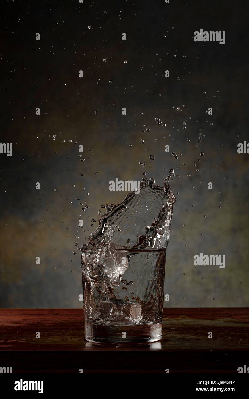 liquid splashing from whiskey glass Stock Photo