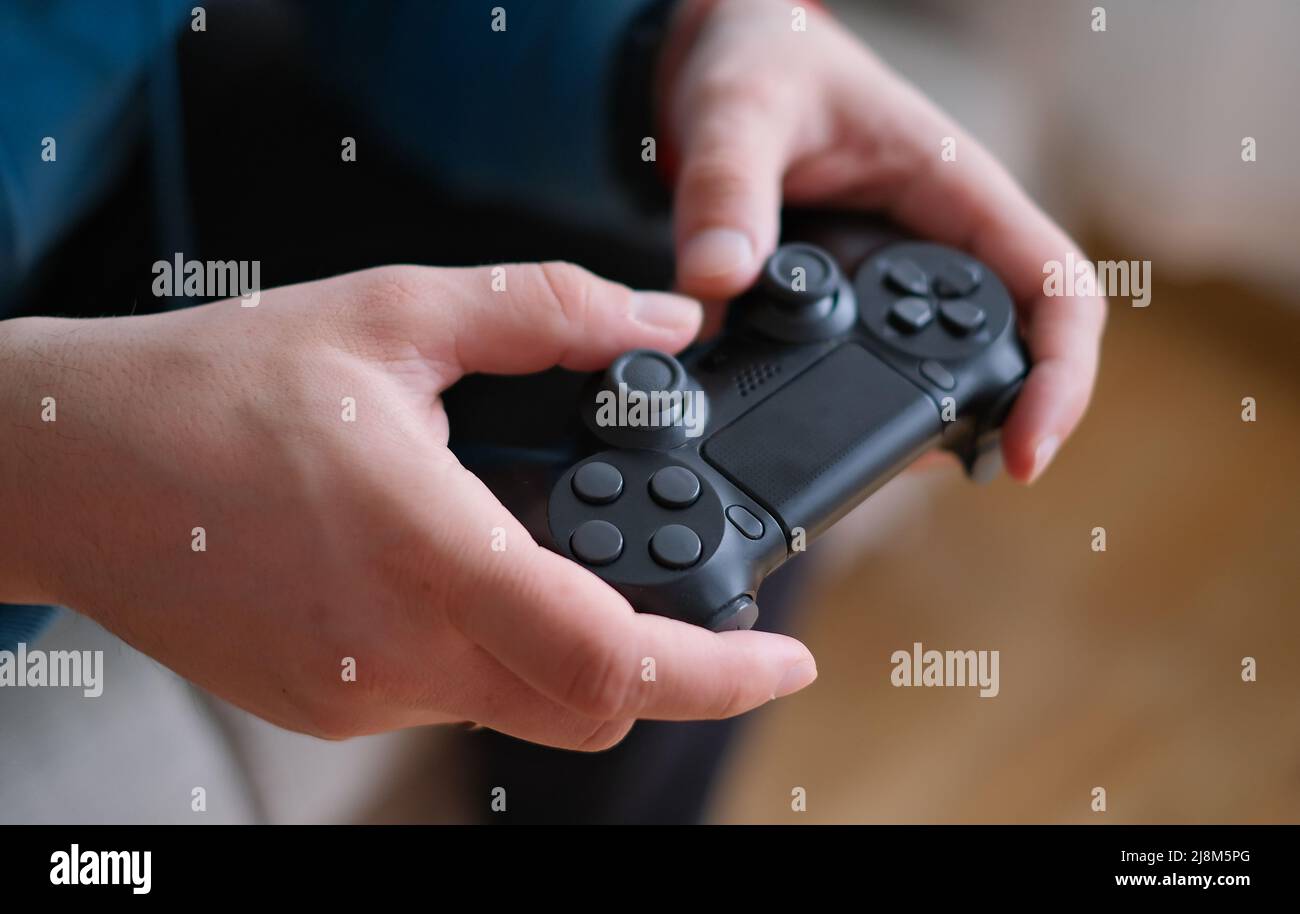 Premium Photo  Close up of gamer holding controller to play video games in  front of computer. player using joystick and playing online games on  monitor, sitting at desk. man gaming with