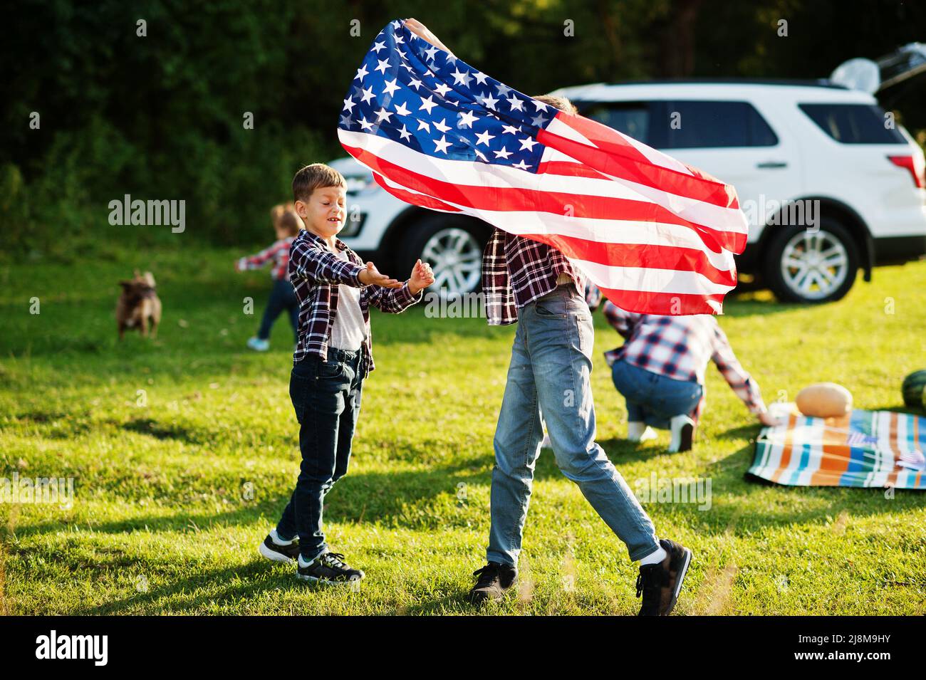 American family spending time together. Brothers play with USA flags