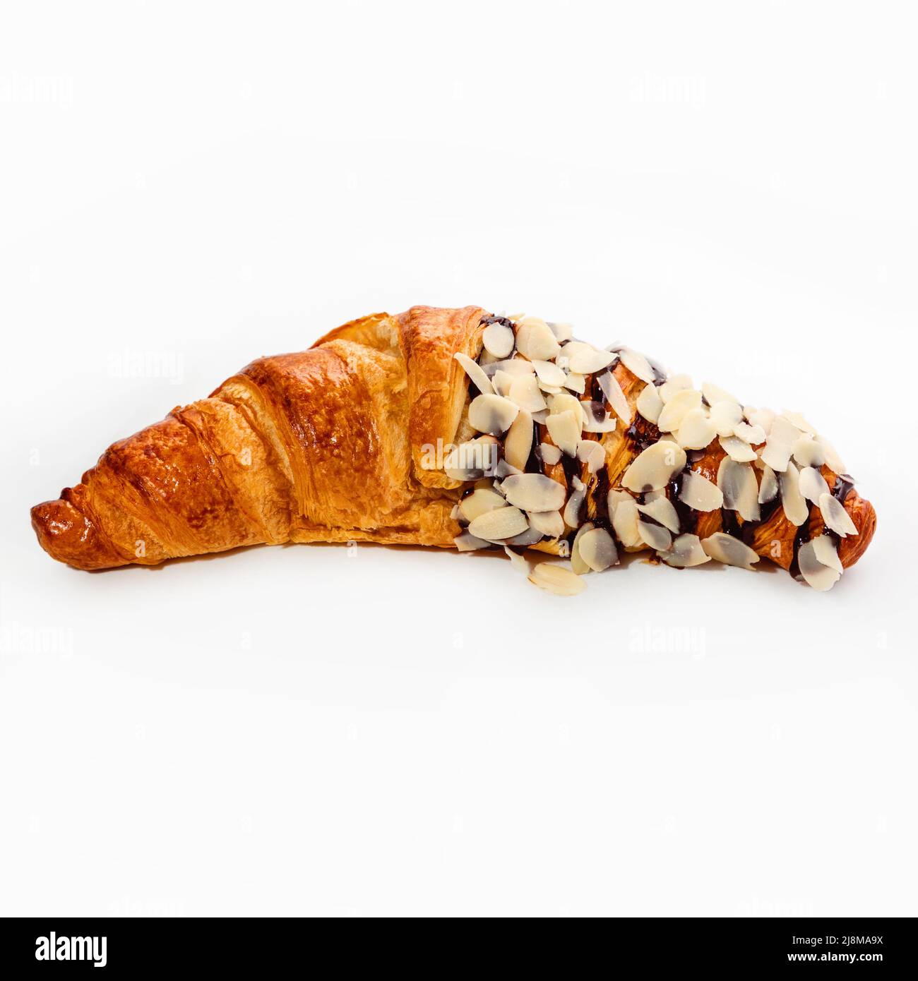 Fresh crispy croissant with chocolate-almond sprinkles on a white background, close-up. Pastries and sweets. Stock Photo