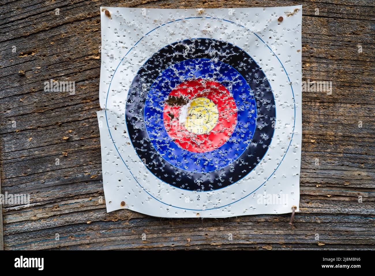 Close-up of an archery shooting target paper with lots of holes. Bullseye in bow and arrow shooting range Stock Photo