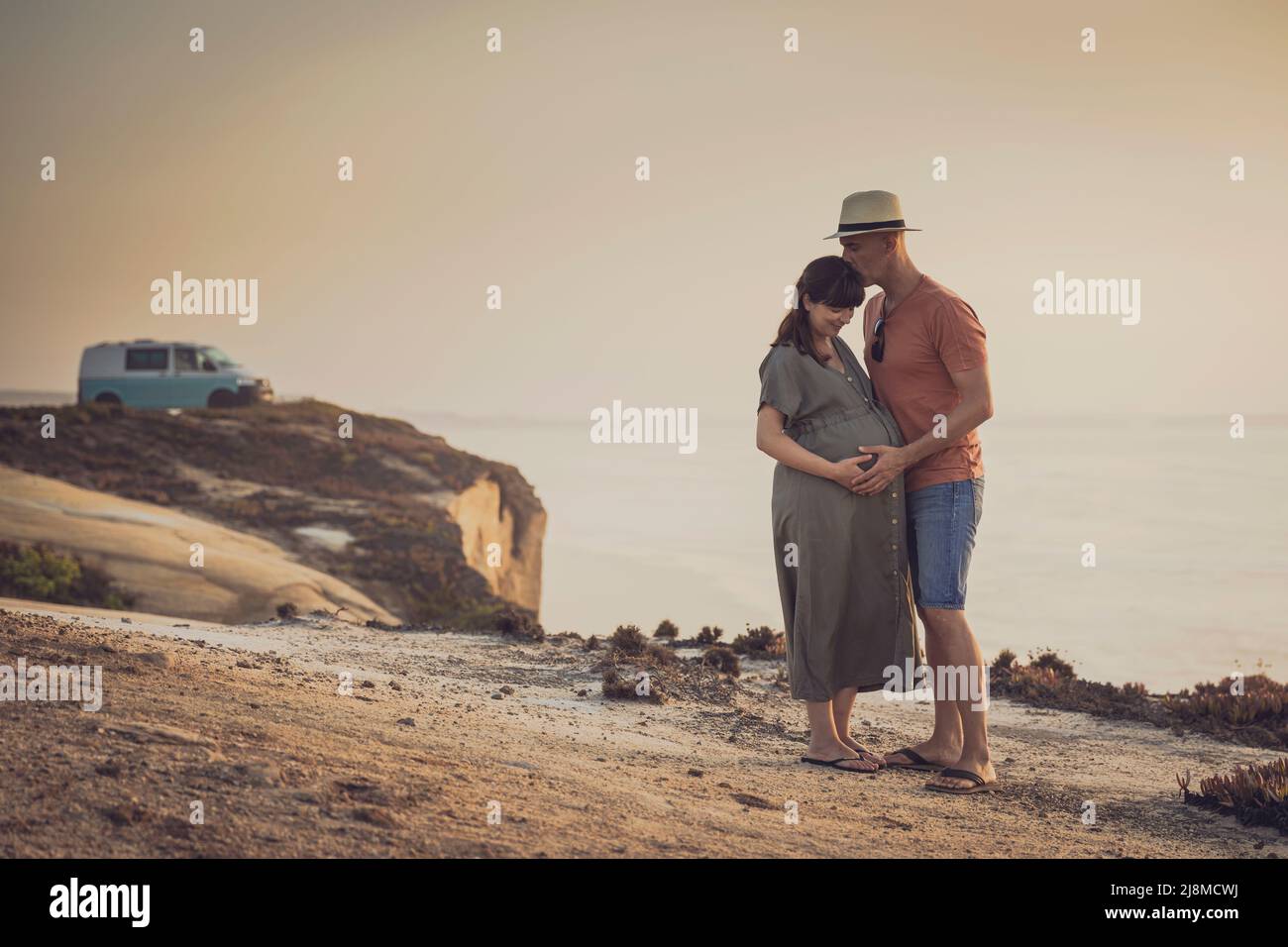 Pregnant couple on a wild beach and their dog expecting a baby Stock Photo