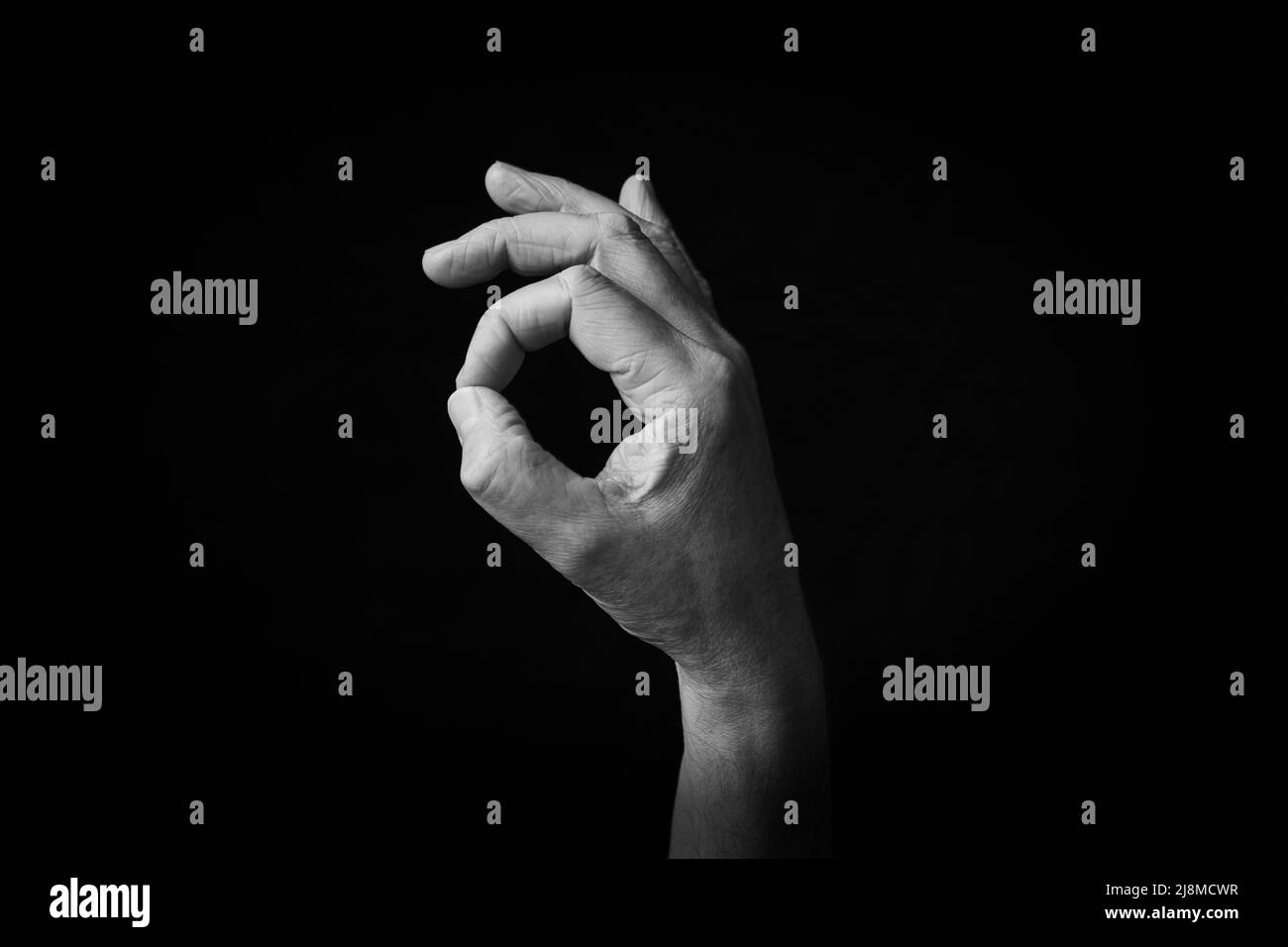 Dramatic black and white image of OK Hand emoji isolated on black ...