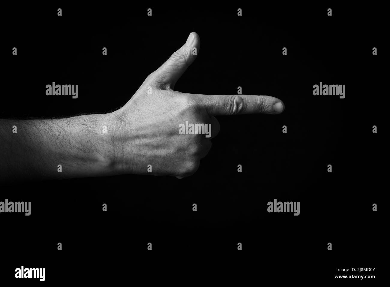 Dramatic black and white image of Backhand Index Pointing Right emoji isolated on black background Stock Photo