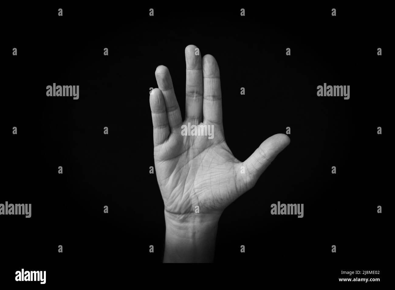 Dramatic black and white image of Vulcan Salute emoji isolated on black background Stock Photo