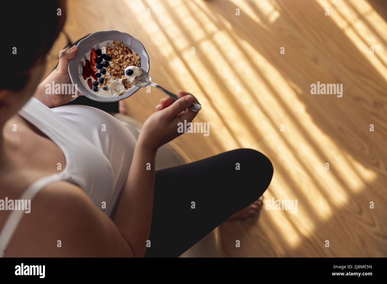 Pregnant woman working at home resting and eating healthy food Stock Photo