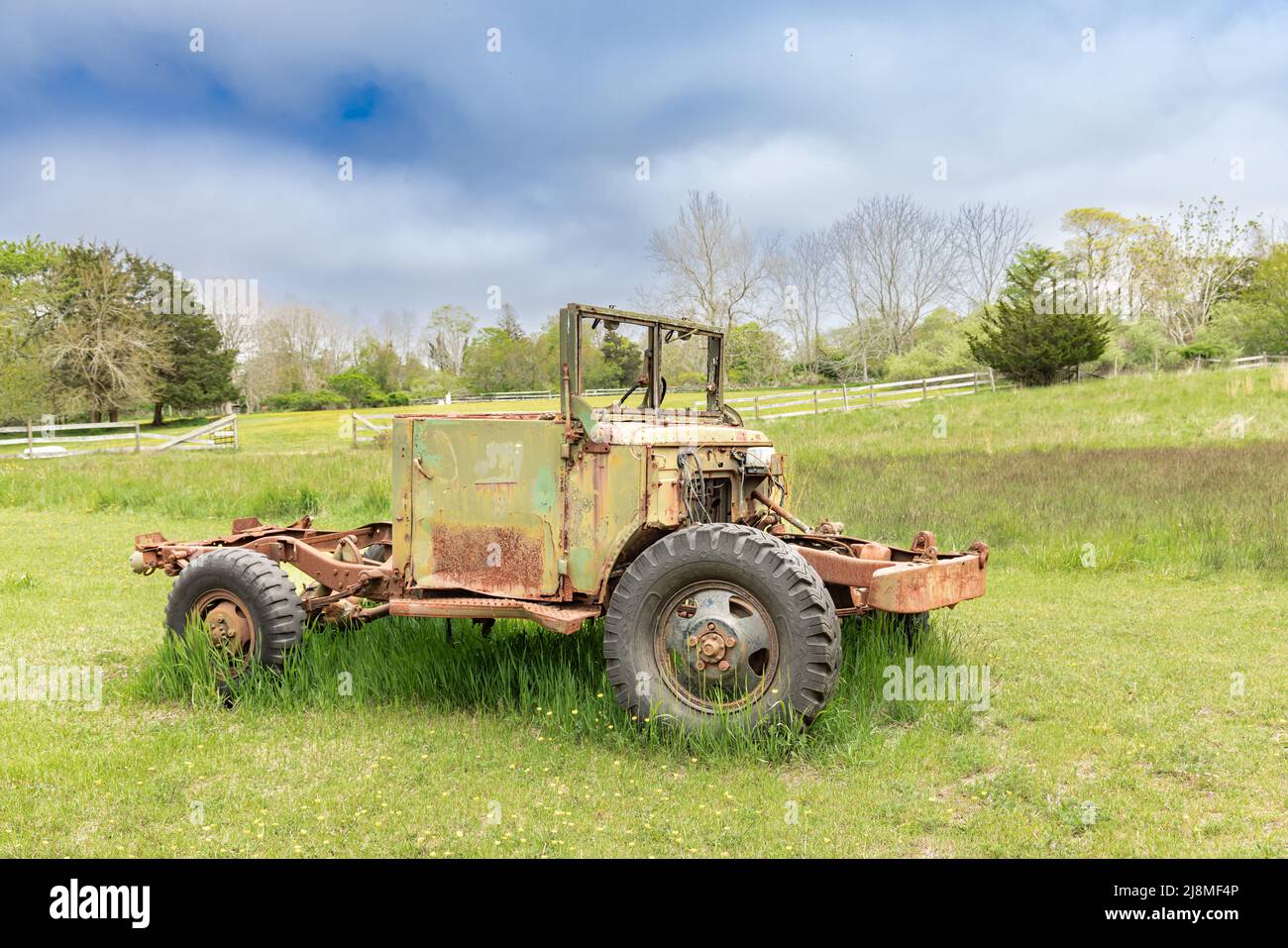 An old vehicle sitting in a green field Stock Photo