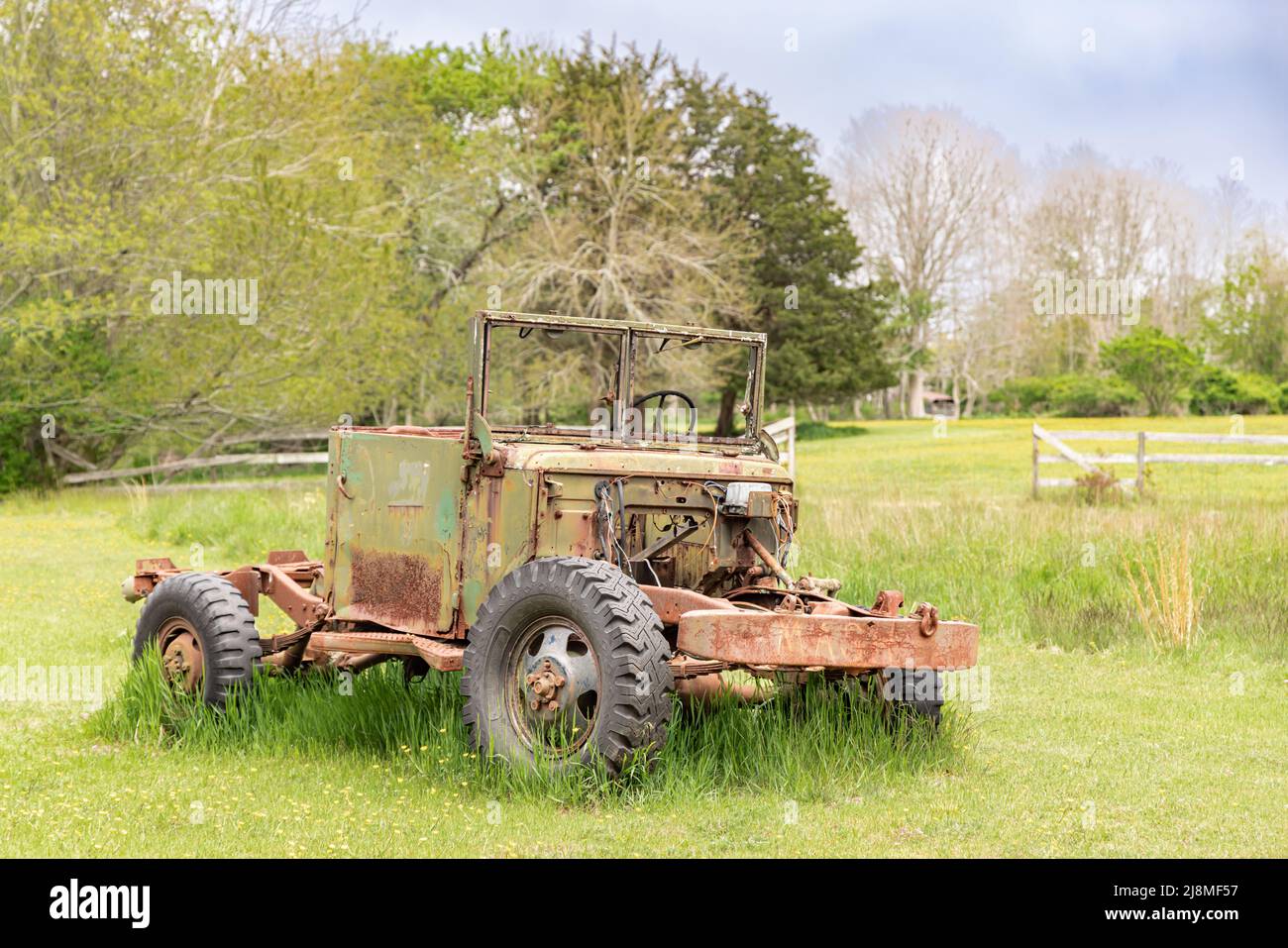 An old vehicle sitting in a green field Stock Photo
