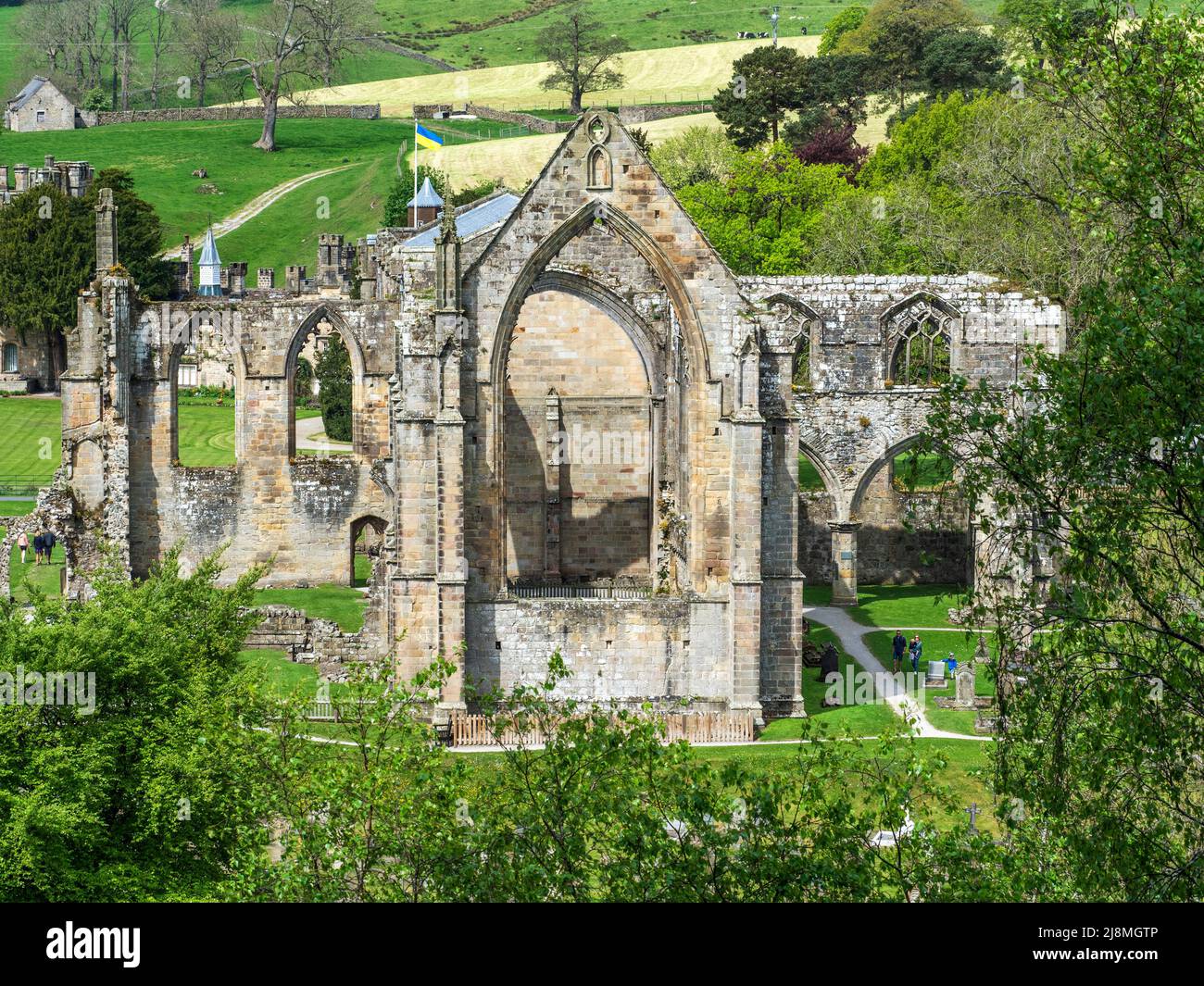Flag of Ukraine flying over the church and priory ruins in May 2022 at Bolton Abbey North Yorkshire England Stock Photo