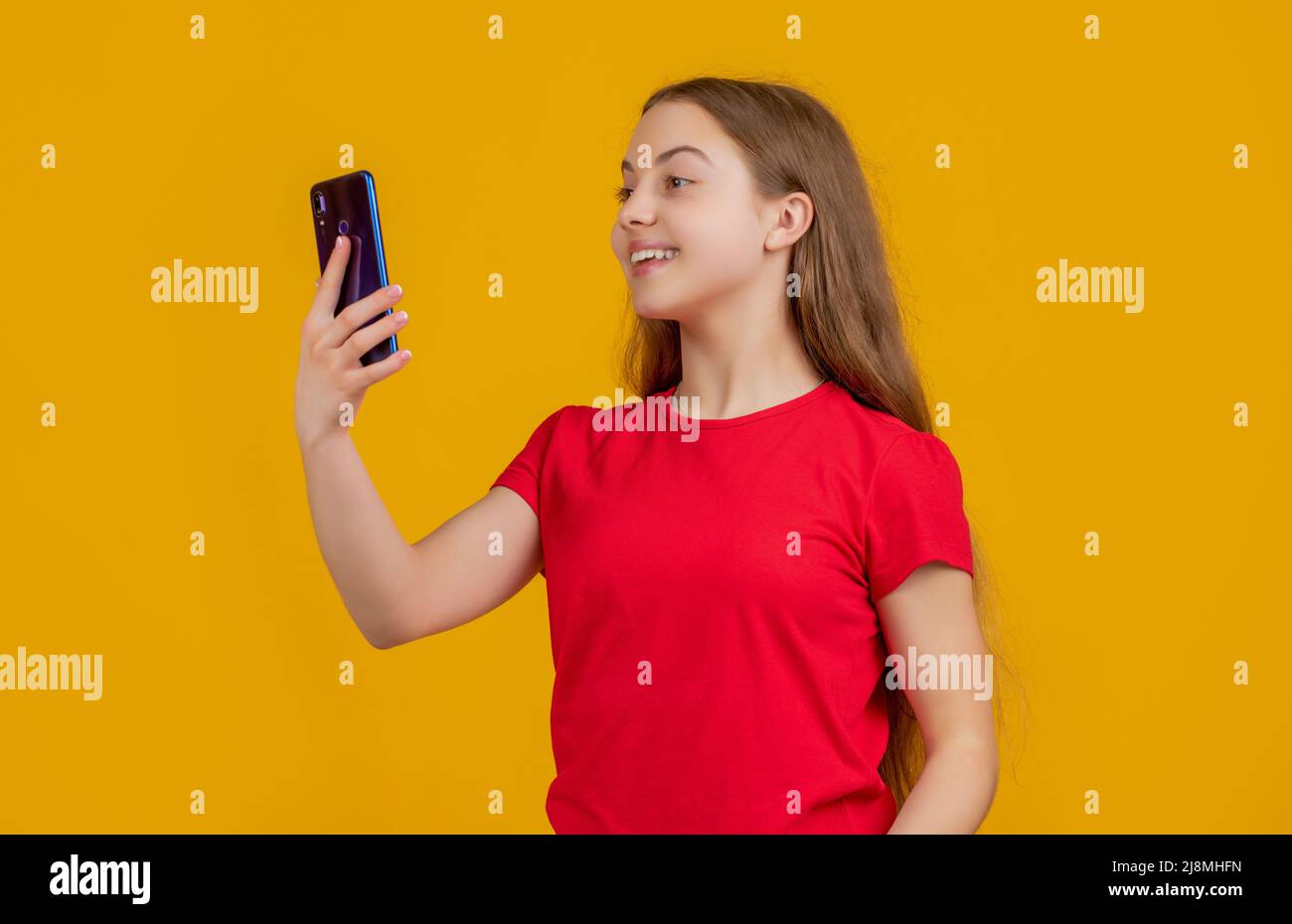 happy teen child with smartphone on yellow background Stock Photo - Alamy