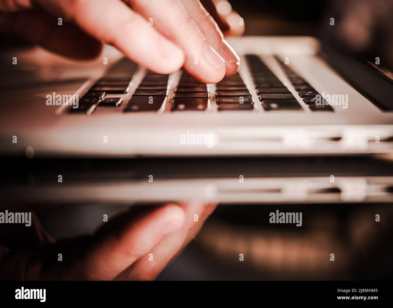 Office Worker Using Laptop Computer on a Glassy Desk. Remote Working Concept. Stock Photo