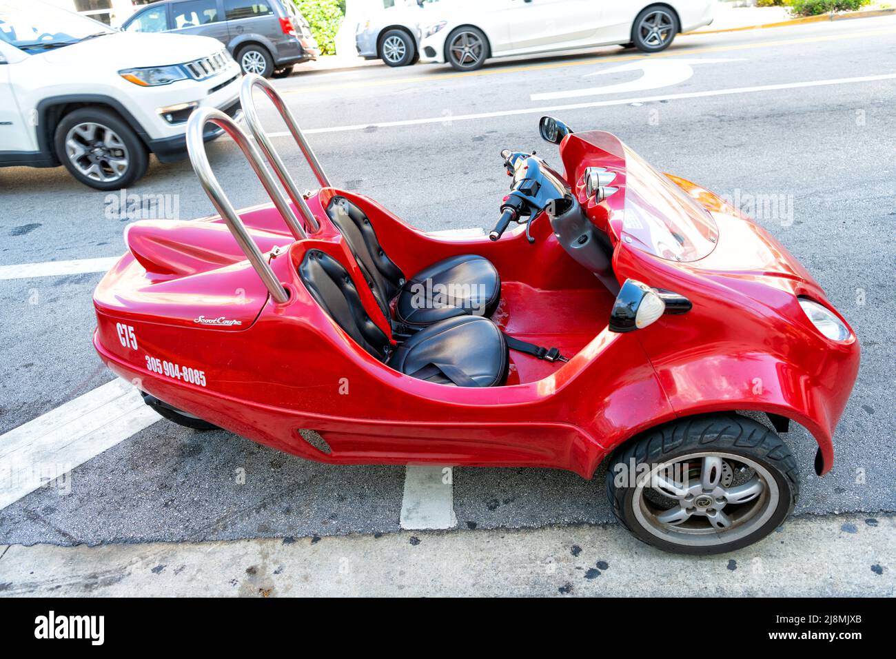 Miami Beach, Florida USA April 14, 2021 red scootcoupe moped, side