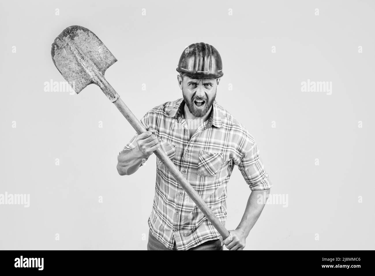 hate his job. man architect with shovel. guy wear worker uniform. handsome builder in helmet. mature man wear checkered shirt. professional Stock Photo