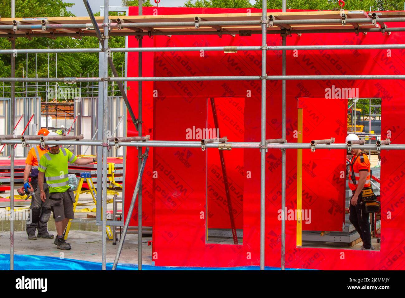 Installing red Wraptite a unique external airtight solution, which is vapour permeable, yet airtight; membrane & insulation on construction site in New Build Care Home in Preston, UK Stock Photo