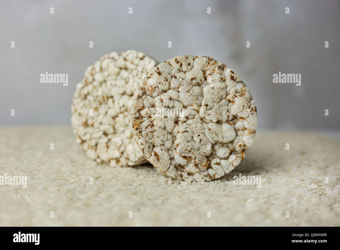 Standing rice buckwheat cake on a background of strewn rice groats