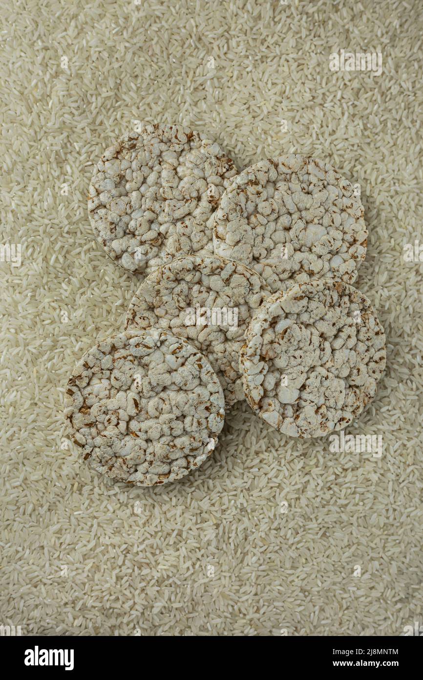 Rice buckwheat cake on a background of strewn rice groats. Top view