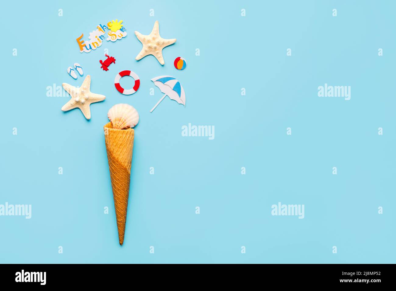 Ice cream cone with sea shells,starfish and beach drawings with space for text over blue background. Summer holiday concept Stock Photo