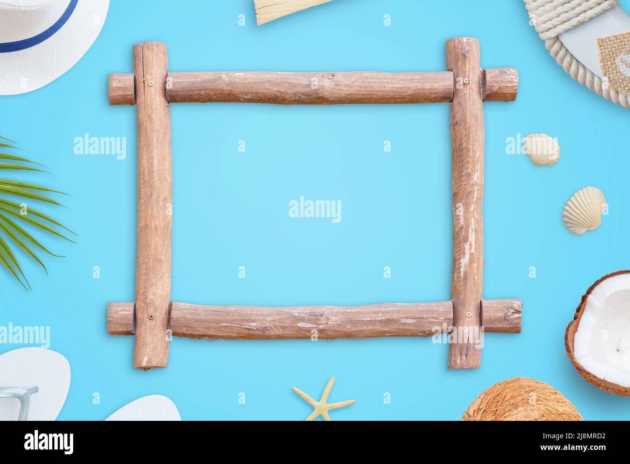 Wooden frame on blue surface. Summer travel concept. Top view, flat lay composition. Free space in the frame for text promotion Stock Photo