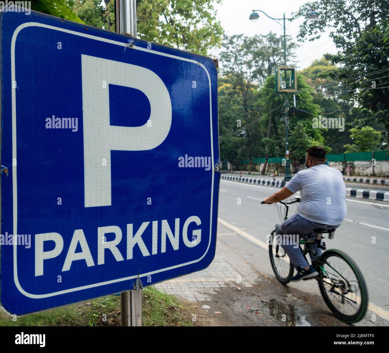 14th July 2020. Uttarakhand, India. A big blue roadside Parking sign with a big P written in white and a man riding in a picture.a Stock Photo