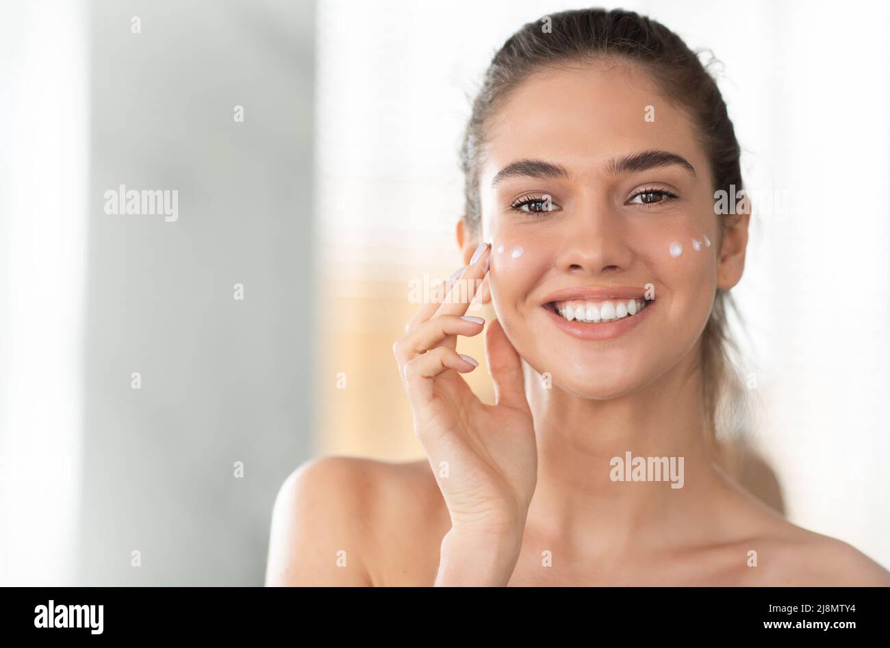 Woman With Moisturizer Dots On Cheeks Applying Facial Cream Indoor Stock Photo Alamy