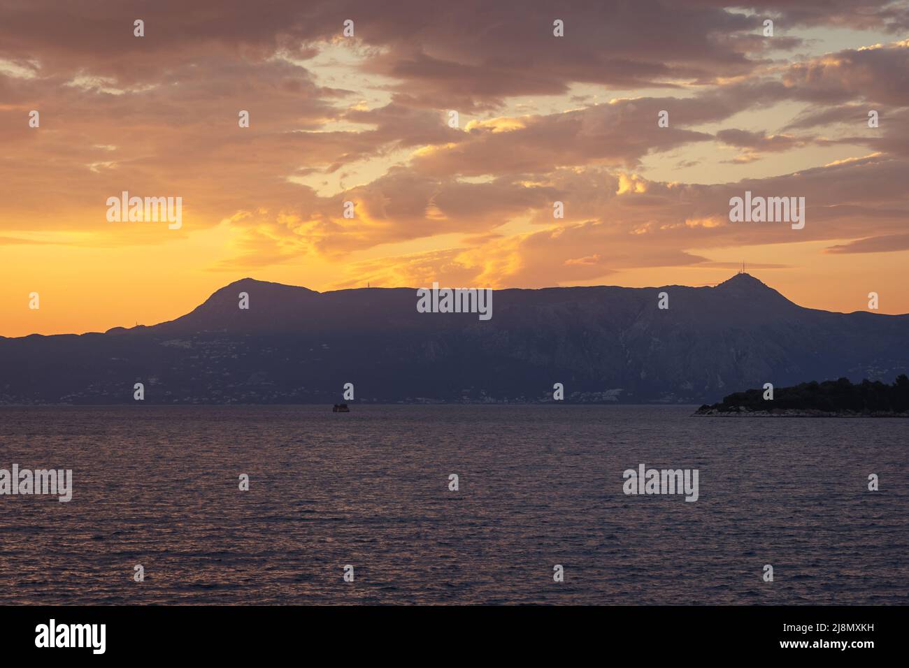 Sunset seen from Old Town of Corfu city on the island of Corfu, Ionian Islands, Greece, view with Mount Pantokrator Stock Photo