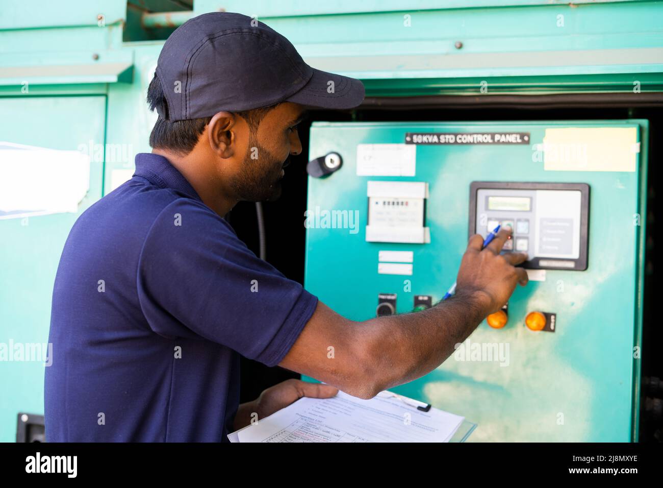 Electrical engineer noting down voltage flow of switch gear or current distribution board at