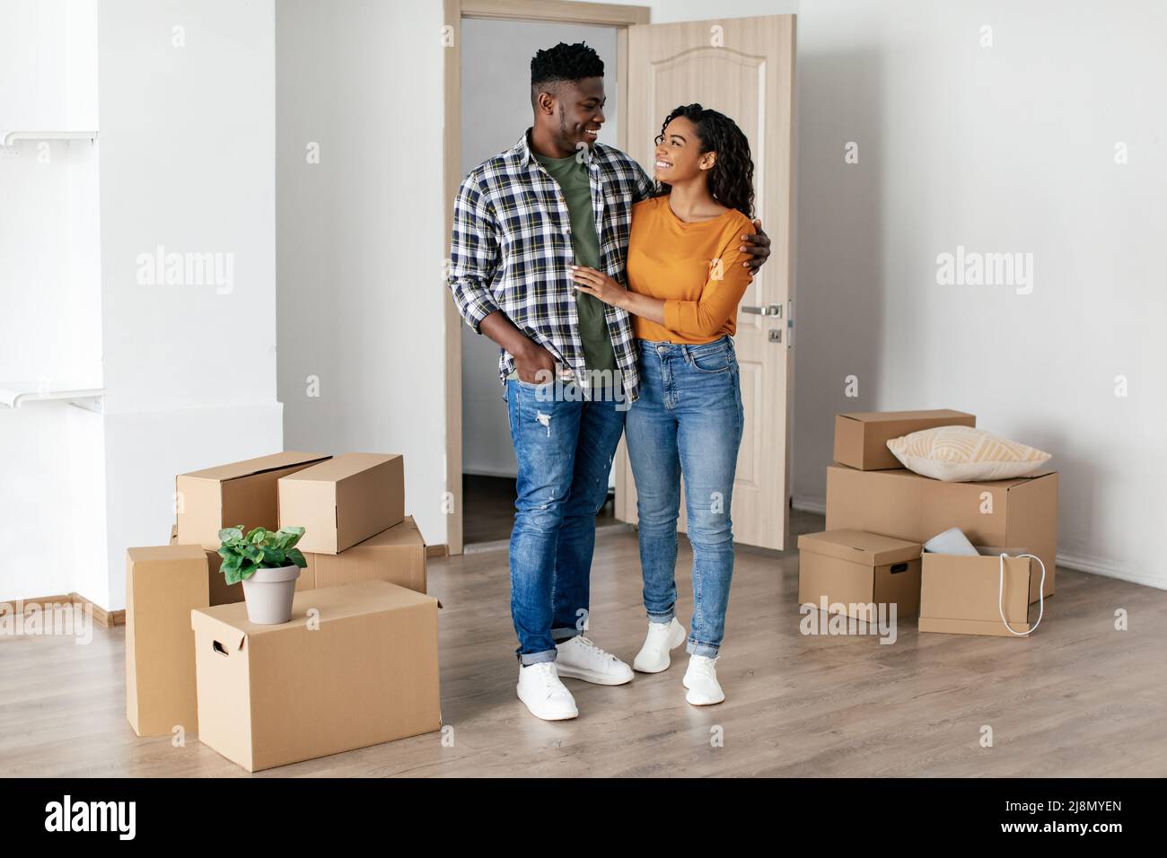 Cheerful African Couple Embracing Standing After Relocation In New Home ...